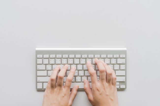 Directly Above Shot Of Person Hands Typing On small Computer Keyboard